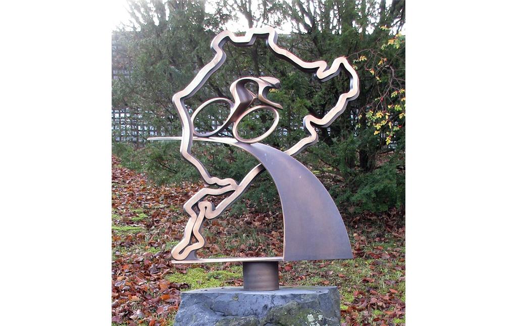 Die bronzene Skulptur am Denkmal "Radsport am Nürburgring" stellt einen Radfahrer dar, der auf einer Bahn durch die bekannte Silhouette der Rennstrecke fährt (2020).