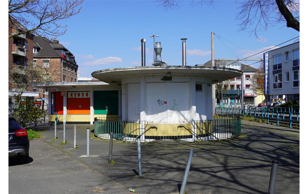 Die ehemalige Wartehalle des Busbahnhofs Porz wurde in den 1950er Jahren errichtet, sie steht unter Denkmalschutz, verfällt jedoch zusehends. Blick auf den Südflügel mit der vormals verglasten Wartehalle, darunter befindet sich die Toilettenanlage (2023).