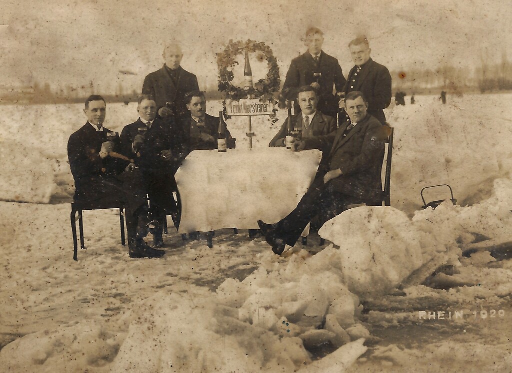 Historische Fotografie mit Herrengruppe und Weinverköstigung auf dem zugefrorenen Rhein bei Nierstein (1929)