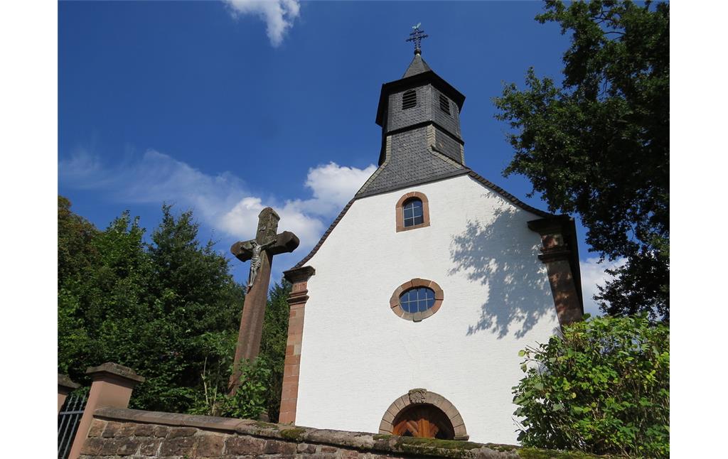 Westansicht der Rochuskapelle in Kaiserslautern Hohenecken. Links daneben ist eine Jesusfigur an einem großen Steinkreuz zu erkennen (2013).
