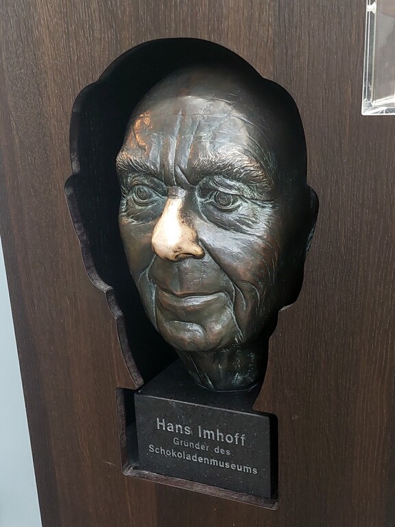 Bronzene Porträtbüste des Schokoladen-Unternehmers Hans Imhoff (1922-2007) in der Ausstellung des von ihm begründeten Schokoladenmuseums am Kölner Rheinauhafen (2023).