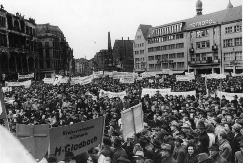 Historische Aufnahme von 1951: Eine Demonstration von Flüchtlings- und Vertriebenenverbänden auf dem Bonner Marktplatz, im Hintergrund rechts das Metropol-Kino-Theater.
