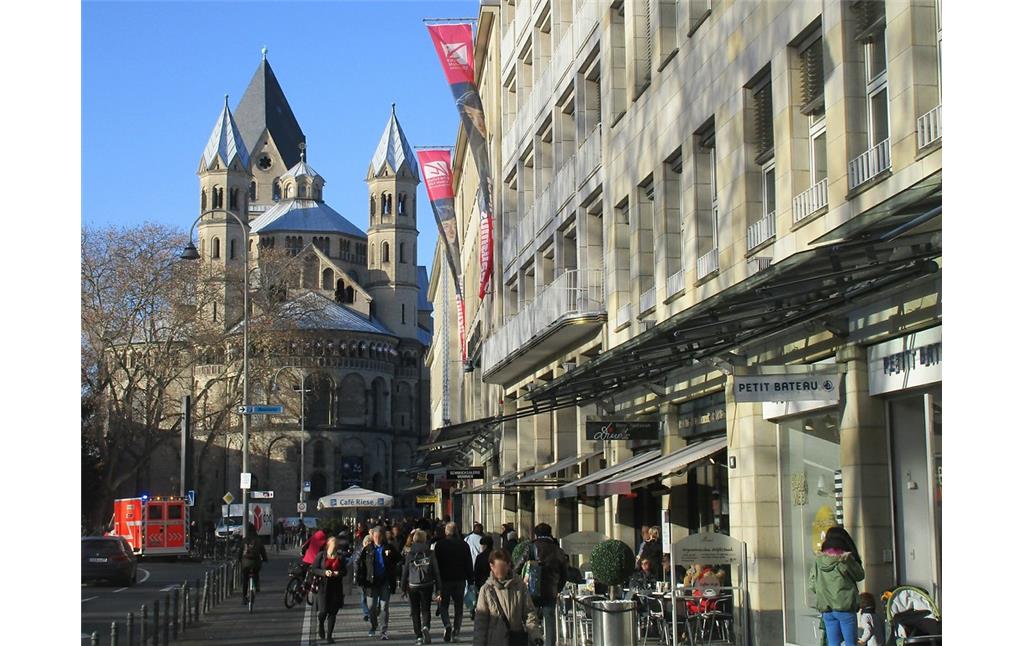Blick von Osten her über Fassaden von Geschäftshäusern nördlich des Kölner Neumarkts in Richtung der früheren Klosterkirche St. Aposteln (2019).