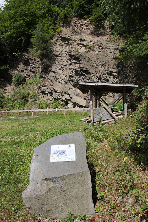 Abbruchkante des ehemaligen Steinbruchs von Bodenbach (2013), im Vordergrund ein Stationsstein der Geschichtsstraße.