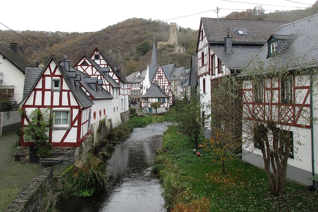 Der Elzbach fließt durch den idyllischen Fachwerkort Monreal, im Hintergrund die Ruine der Philippsburg (2020).