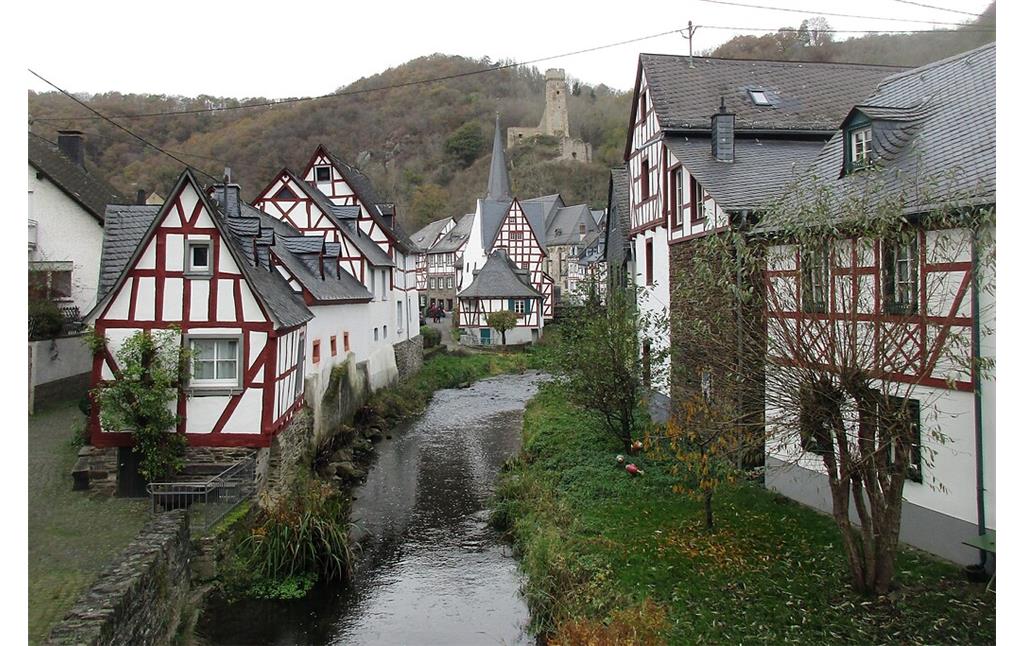 Der Elzbach fließt durch den idyllischen Fachwerkort Monreal, im Hintergrund die Ruine der Philippsburg (2020).