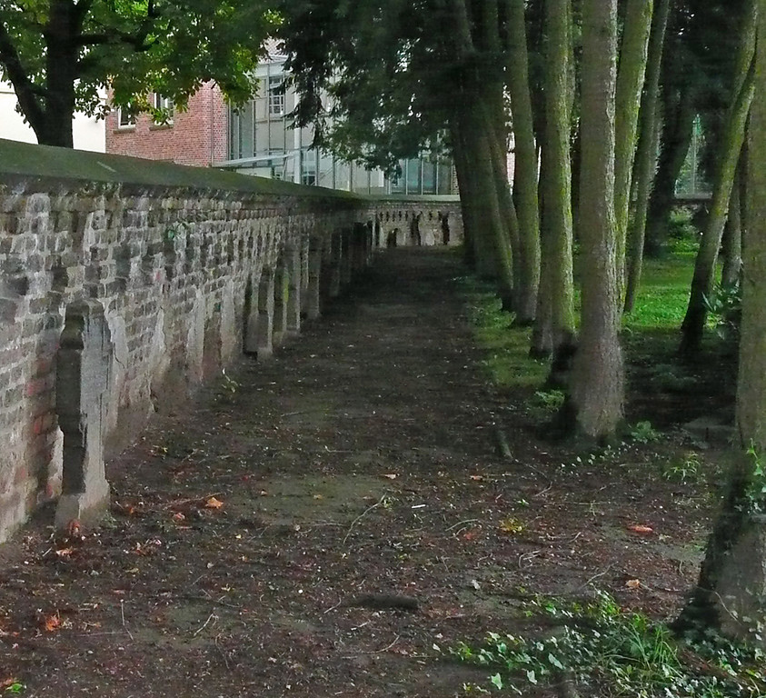 Historische Grabsteine entlang der Friedhofsmauer auf dem Friedhof in Vilich bei der Stiftskirche Sankt Peter (2014)