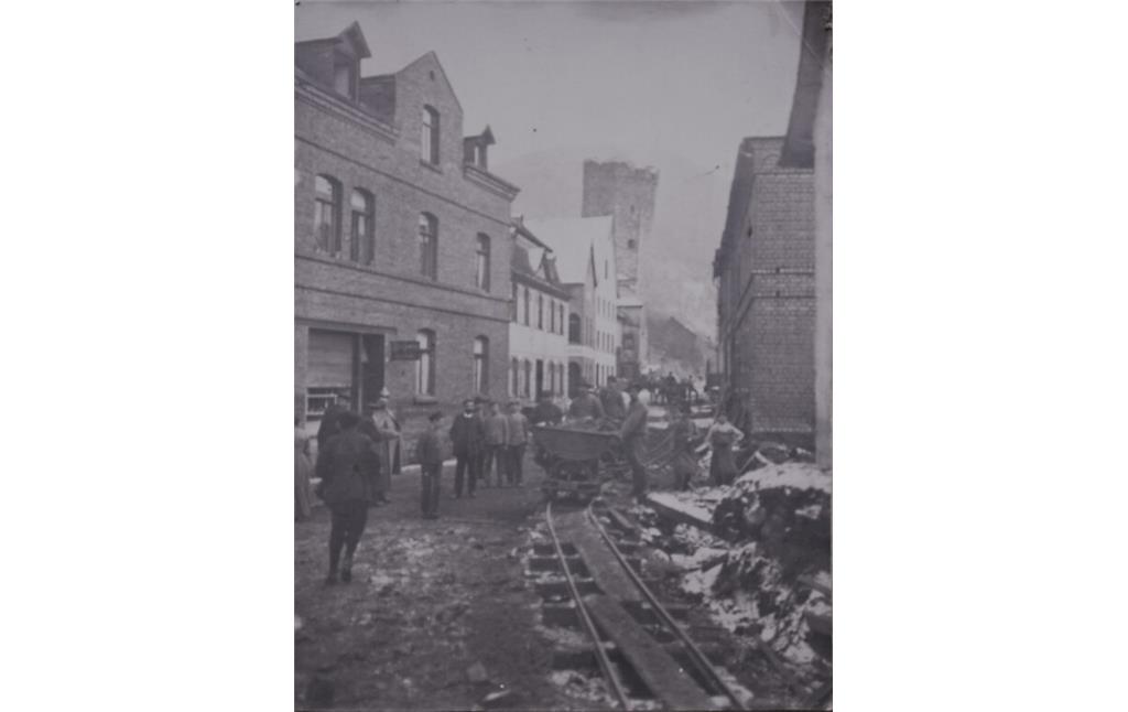 Historische Fotografie der Feldbahngeleise und Feldbahn in der Lahnstraße in Dausenau, im Hintergrund der schiefe Turm (1909)