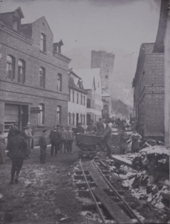 Historische Fotografie der Feldbahngeleise und Feldbahn in der Lahnstraße in Dausenau, im Hintergrund der schiefe Turm (1909)