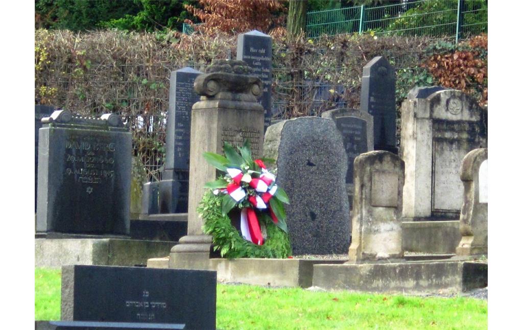 Gräberreihen auf dem jüdischen Friedhof an der Hugostraße in Barmen, in der Mitte ein Gedenkstein, an dem ein Kranz niedergelegt wurde (2014).