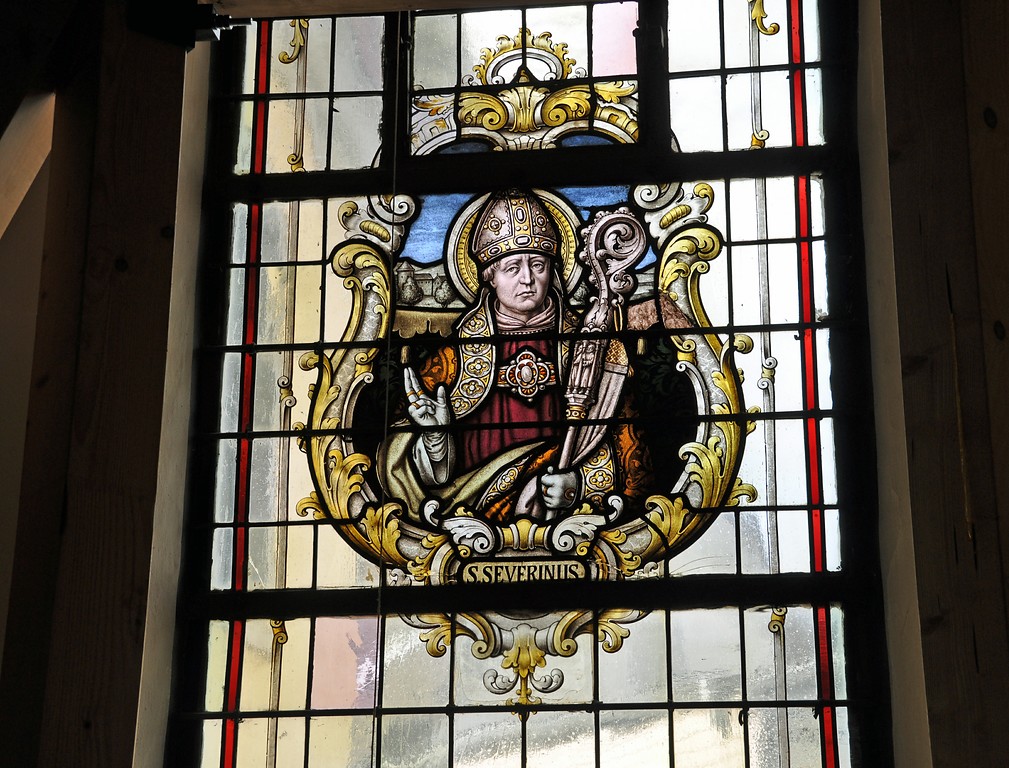 Kirchenfenster in der Nordfassade der Versöhnungskirche in Buschhoven. Abgebildet wird der heilige Severinus (2016)