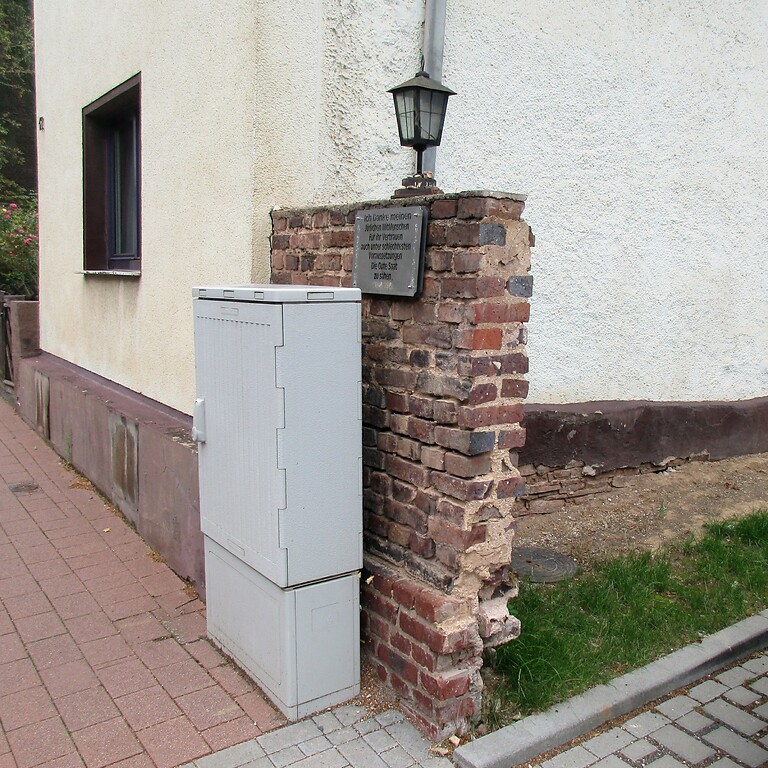 Der erhaltene Rest einer erkennbar älteren Ziegelmauer am früheren Standort der 1938/39 abgerissenen Synagoge Mechernich in der Rathergasse (2020).