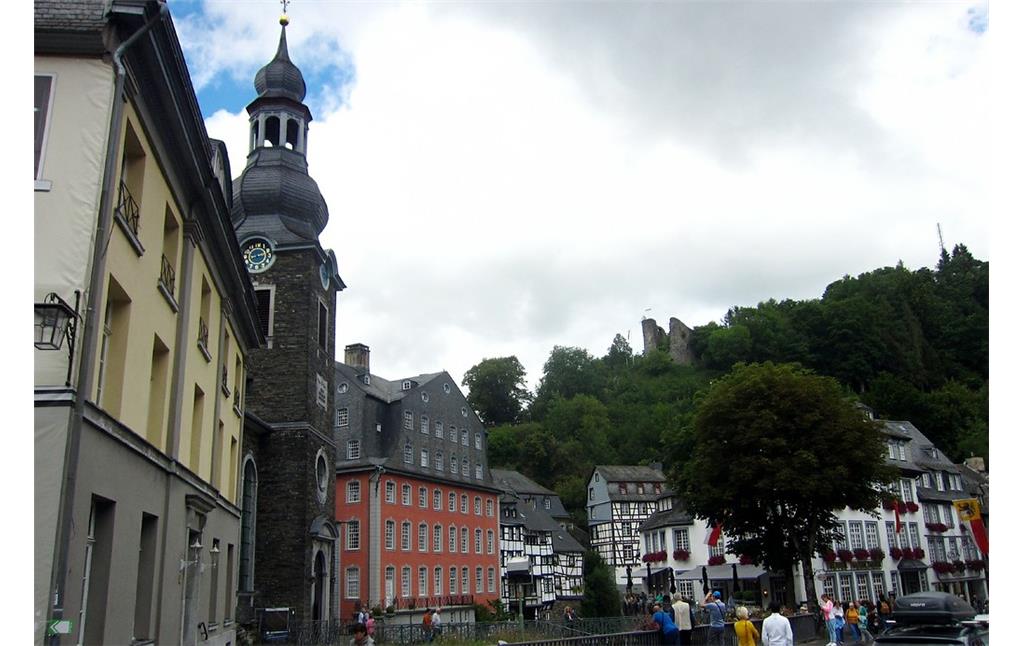 Das Wohn- und Geschäftshaus der Tuchmacherfamilie Scheibler, das "Rote Haus" in Monschau (2015). Links dabeben die von der Familie Scheibler gestiftete evangelische Pfarrkirche von 1787-1789 und im Hintergrund die Ruinen der Befestigungsanlage "Haller".