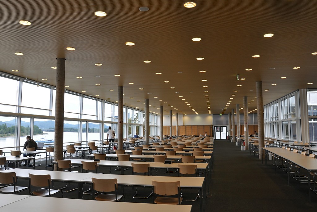 Ansicht des Lesesaals der Universitäts- und Landesbibliothek Bonn. Die vollständig verglaste Fassade an der linken Seite beginnend gibt den Blick auf den Rhein sowie auf das Siebengebirge frei (2017).