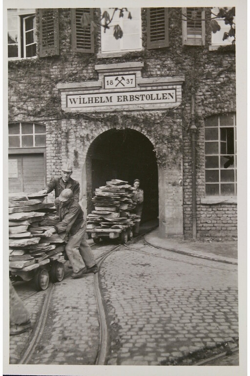 Die bergfeuchten Schieferplatten werden aus dem Wilhelm-Erbstollen an die Verarbeitungsstätten über Tage gebracht (um 1920)