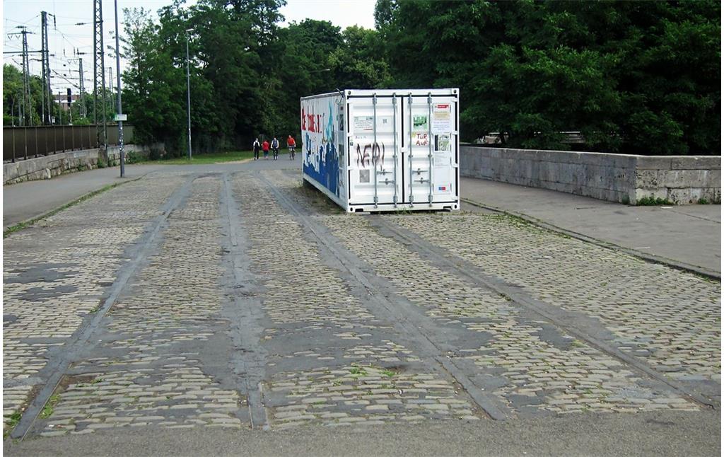 Im Kopfsteinpflaster erhaltene Gleise der früheren Straßenbahn, die vor dem Zweiten Weltkrieg über die Kölner Hohenzollernbrücke fuhr, am südöstlichen Brückenzugang in Deutz (2015).