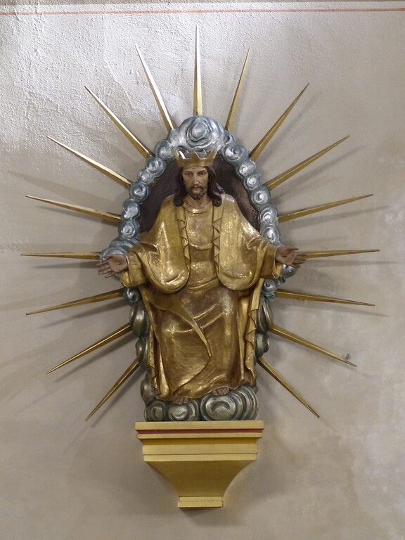 Skulptur von Christus als Weltenherrscher an der Wand rechts der Eingangstür zum romanischen Bauteil in der Kirche Maria Geburt in Berglicht (2022)