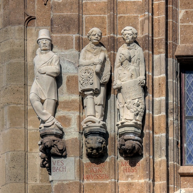Steinerne Figuren am Rathausturm Köln, dargestellt sind Jacques Offenbach, Gustav von Mevissen und Moses Hess (auch Moritz Heß) (v.l.n.r., Aufnahme 2009).