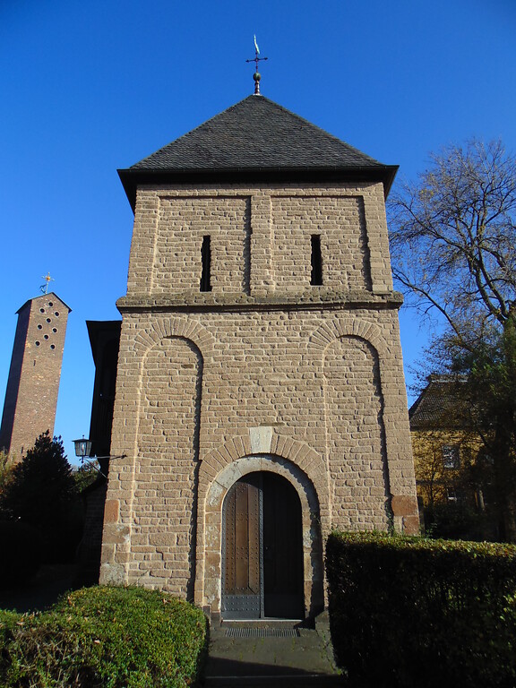 Blick auf die Frontseite samt Eingangsportal des Krieler Dömchens in Köln-Lindenthal (2020). Links dahinter ragt der Turm der Kirche St. Albertus-Magnus empor.