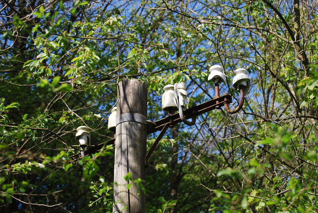 Ehemaliger Telegraphenmast im Bahnhof Kronenburg in Dahlem, Tragbalken mit Isolatoren für die Befestigung der Leitungen (2014)