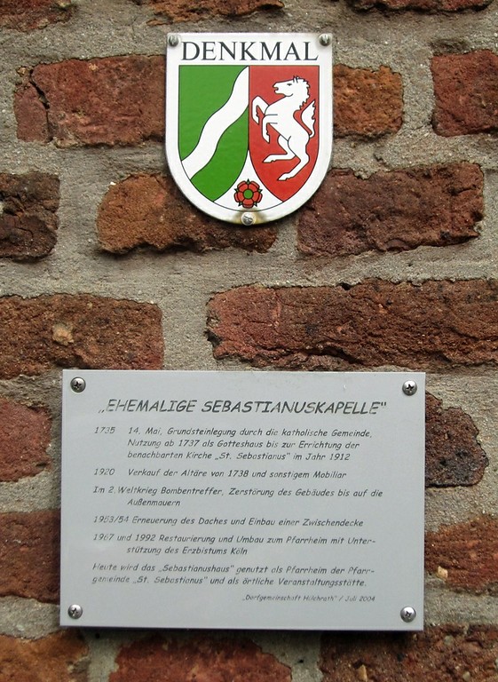 Die Denkmalplakette und eine Informationstafel an der ehemaligen Sebastianuskapelle in Hülchrath (2014)