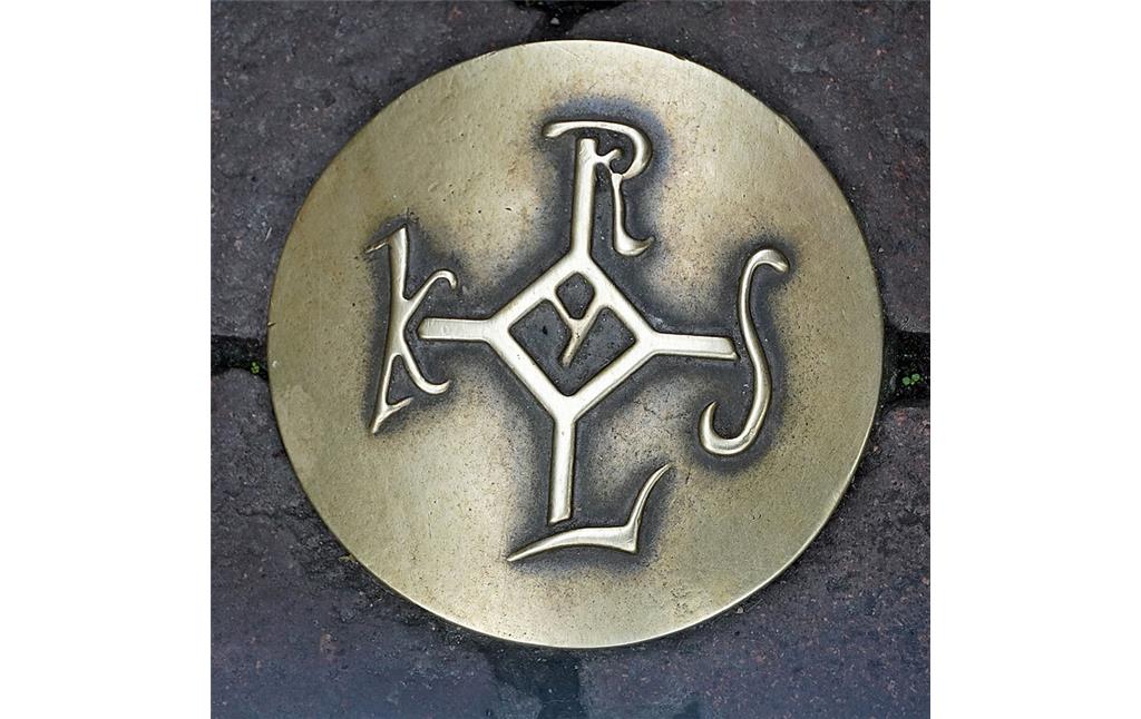 Bronzenes Karolus-Monogramm, auch Karlsmonogramm, als Wegweiser eines Kulturpfades in Aachen-Mitte 2021). Das vorgeschriebene Signum diente als die Unterschrift des Kaisers, welche er mit dem sogenannten Vollziehungsstrich vollendete.