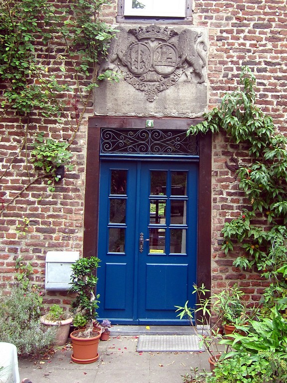 Eingang zum nordöstlichen Wirtschaftsgebäude von Schloß Bachem mit krönender Wappentafel (2013)