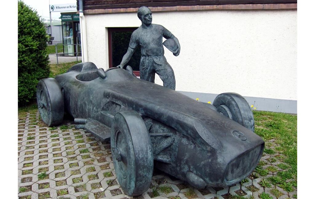 Das 2002 errichtete Denkmal für Juan Manuel Fangio am Nürburgring (2015). Es stellt den argentinischen Automobilrennfahrer mit einem Mercedes-Benz W 196 "Silberpfeil" dar.