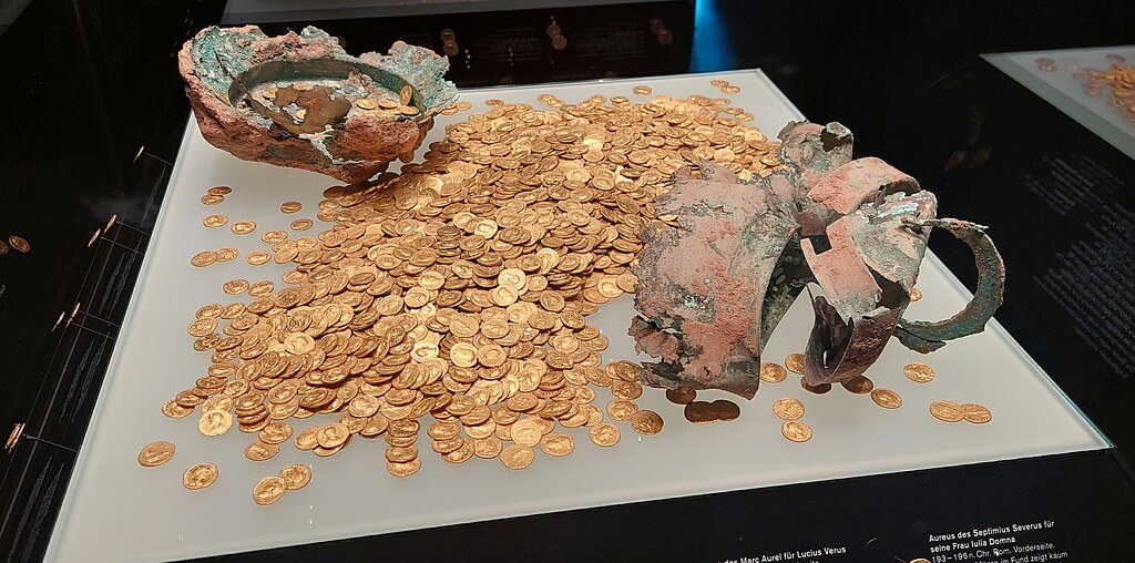 Der 1993 bei Bauarbeiten nahe der früheren Abtei St. Irminen aufgefundene Trierer Goldmünzenschatz mit 2.650 Aurei aus den Jahren 63 bis 168 n. Chr. Der größte Hortfund von Goldmünzen der römischen Kaiserzeit mit einem Gewicht von ca. 18,5 Kilogramm wird im Rheinischen Landesmuseum Trier präsentiert (2022).