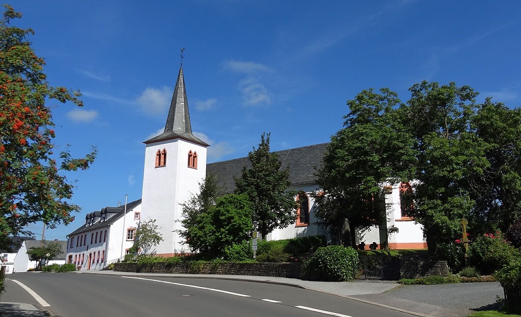 Die katholische Pfarrkirche St. Luzia in Habscheid im Eifelkreis Bitburg-Prüm, dahinter das Gemeindehaus.