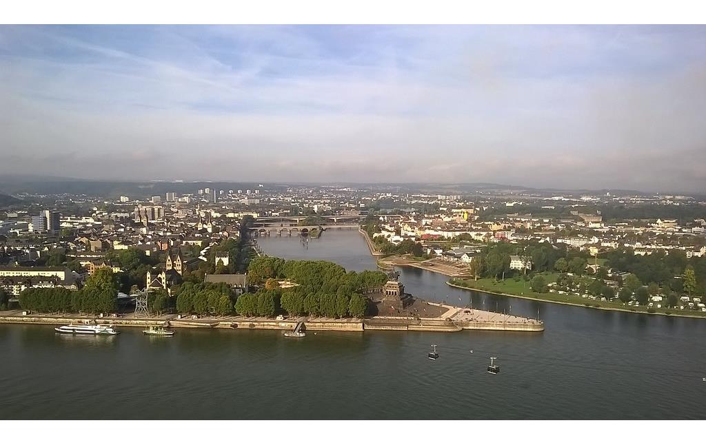 Das Deutsche Eck in Koblenz, am Zusammenfluss von Rhein und Mosel, mit dem Kaiser-Wilhelm-Denkmal von der Festung Ehrenbreitstein aus (2014). In der Bildmitte ist die "Balduinbrücke" über die Mosel zu sehen.
