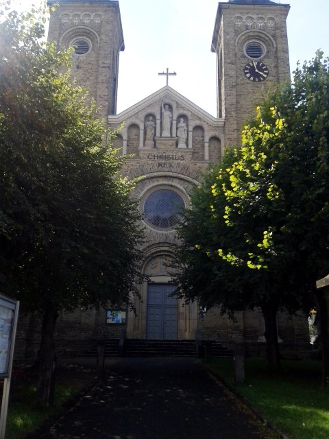 Die katholischen Pfarrkirche St. Servatius in Güls in Koblenz. Zu erkennen sind das Portal, das Rosettenfenster und drei Steinskulpturen (Jesus Christus, Petrus und Paulus) (2014).