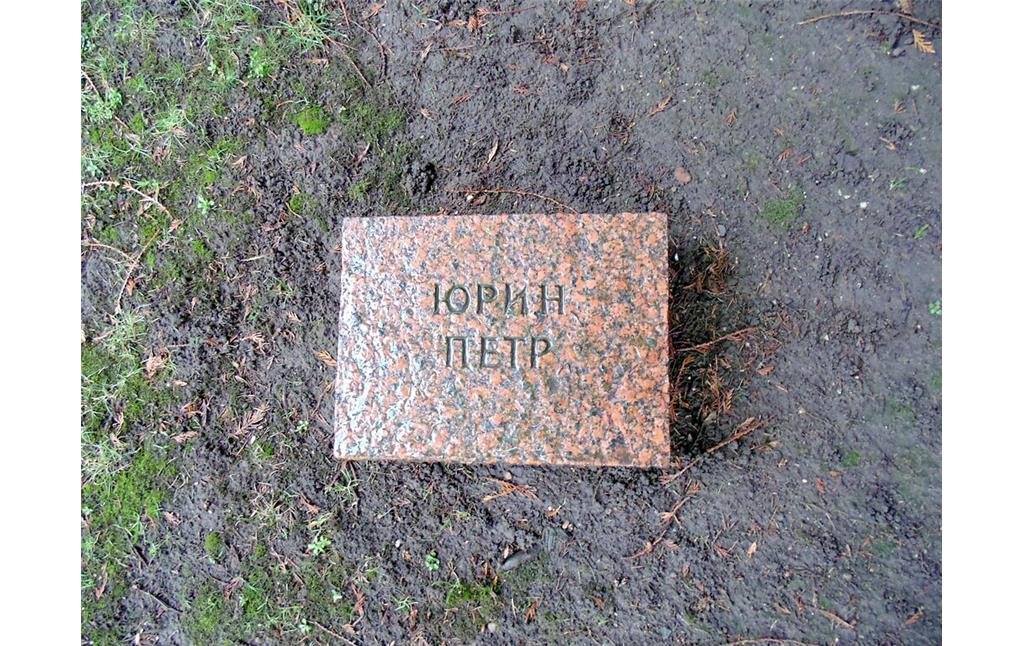 Ein Grabstein auf dem Gräberfeld für sowjetische Kriegsgefangene auf dem Westfriedhof in Köln-Vogelsang (2021). Die Inschrift lautet übersetzt "Jurin Petr".