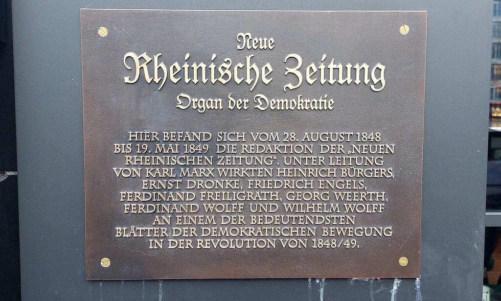 Plakette am Haus Nr. 65 auf dem Kölner Heumarkt (2022), in den Jahren 1848/49 Redaktionssitz der "Neuen Rheinischen Zeitung" unter der Leitung von Karl Marx.