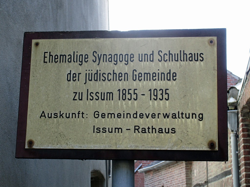Hinweisschild, welches auf die ehemalige Synagoge mit jüdischer Mikwe (Ritualbad) und Schulhaus, heute Gedenkstätte in der  Kapellener Straße in Issum, hinweist (2016).