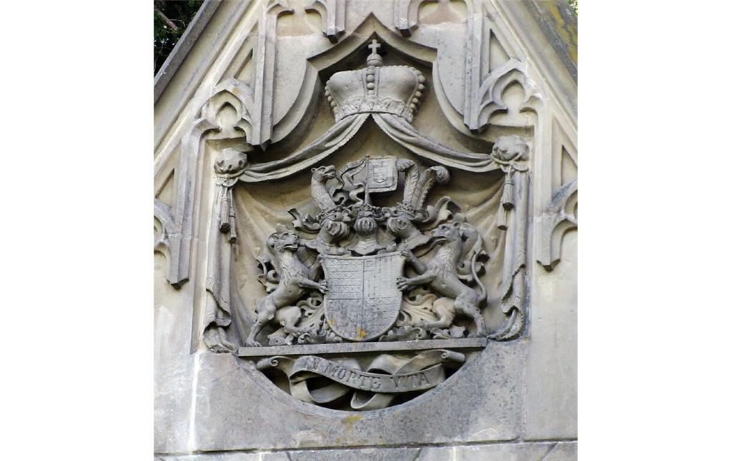 Das von Löwen gestützte Wappenschild der Grafen Berghe von Trips mit Schildhaltern, Helmzier, Mantel und Fürstenhut, darunter die lateinische Inschrift "in morte vita" an der Familiengruft auf dem Friedhof in Kerpen-Horrem (2022).