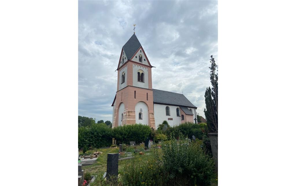 Die katholische Kirche St. Michael in Köln-Zündorf, Blick in Richtung Norden (2023).Die katholische Kirche St. Michael in Köln-Zündorf, Blick auf den Westturm (2023). Im Vordergrund liegt der Friedhof von Niederzündorf.