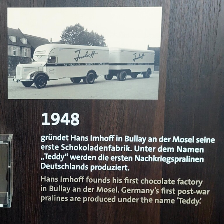 Hinweis auf die 1948 erfolgte Gründung der Schokoladen- und Pralinenfabrik "Teddy Schokoladen- und Zuckerwarenfabrik" in Bullay an der Mosel durch Hans Imhoff in der Ausstellung des Kölner Schokoladenmuseums am Rheinauhafen (2023).