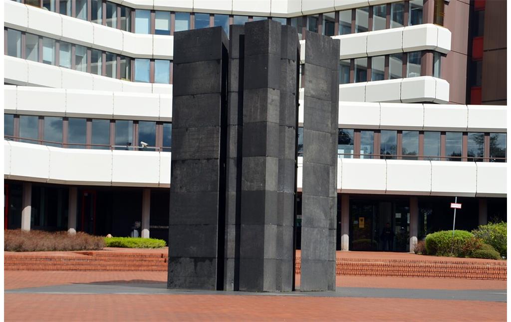 Die Basaltskulptur "Lichtdurchlässige Bündelsäule" vor dem Bundesverwaltungsamt in Köln-Riehl (2022), ein Werk des Künstlers Erwin Heerich (1922-2004).