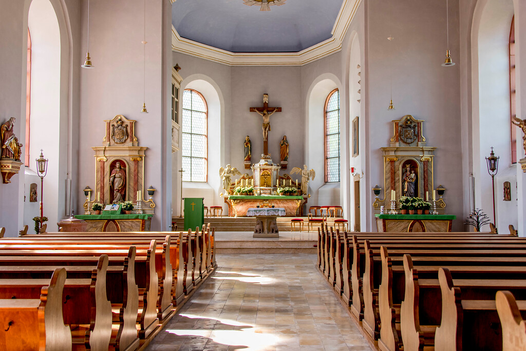 Blick in den Innenraum mit den beiden Seitenaltären und in die Apsis mit dem Hauptaltar der Pfarrkirche Mariä Geburt in Bretzenheim (2022)