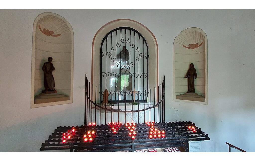 Der Altar der 1686 errichteten Wallfahrtskapelle im Rheinbacher Stadtwald (2022). Der hier verehrte Holzscheit mit dem Christusmonogramm "IHS" ist eine 1986 geschaffene Replik des 1984 gestohlenen silbergefassten Holzscheits.