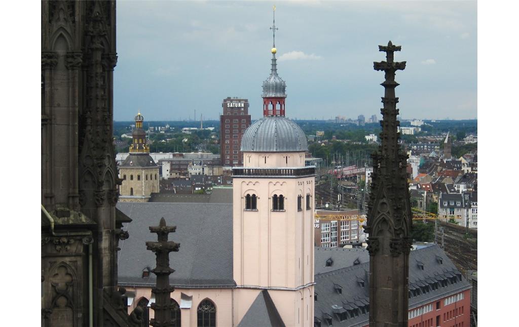 Kirchturm des Jesuitenkollegs Sankt Mariä Himmelfahrt in Köln, dahinter links der Turm des Ursulastifts und das Saturn-Hochhaus (Hansahochhaus), Ansicht vom Dach des Kölner Doms aus (2014).