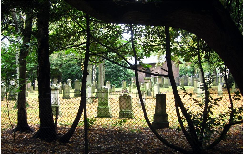 Grabmale und die Trauerhalle sowie ein Teil des Zauns des Alten Jüdischen Friedhofs an der Heideckstraße in Krefeld, Ansicht von Außen (2014).