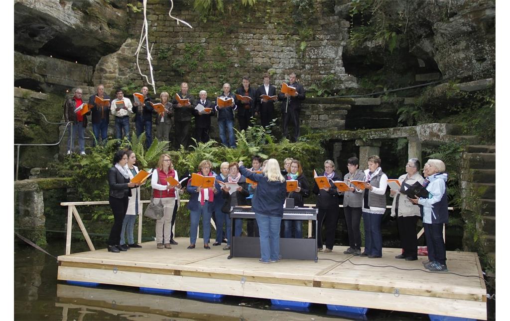 Eine Choraufführung im Rahmen der kulturellen Nutzung des Felsenweihers "Pastors Garten" bei Ernzen (2015).