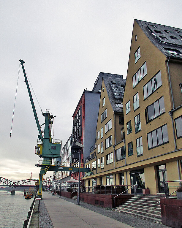 Das Danziger Lagerhaus "Siebengebirge" sowie das "Silo 23" mit der roten Fassade und der historische Hafenkran Nr. 31a im Rheinauhafen in Köln-Altstadt-Süd (2021).