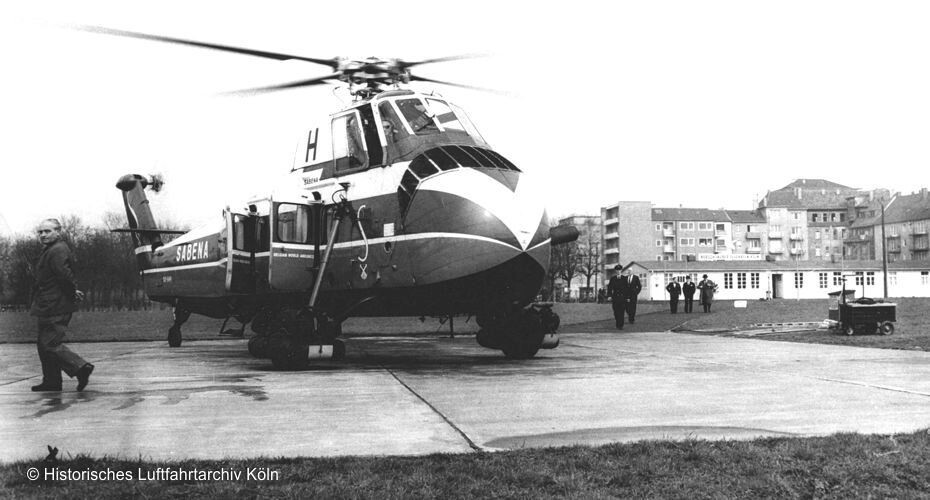 Ein im Hubschrauber-Linienflugverkehr der belgischen Fluggesellschaft Sabena eingesetzter Helikopter vom Typ Sikorsky S-58 (Aufnahme zwischen 1953 und 1958), hier auf der Landeplattform des Hubschrauberflughafens Köln, links im Bild der Chef des Kölner Heliports Franz Knapp.