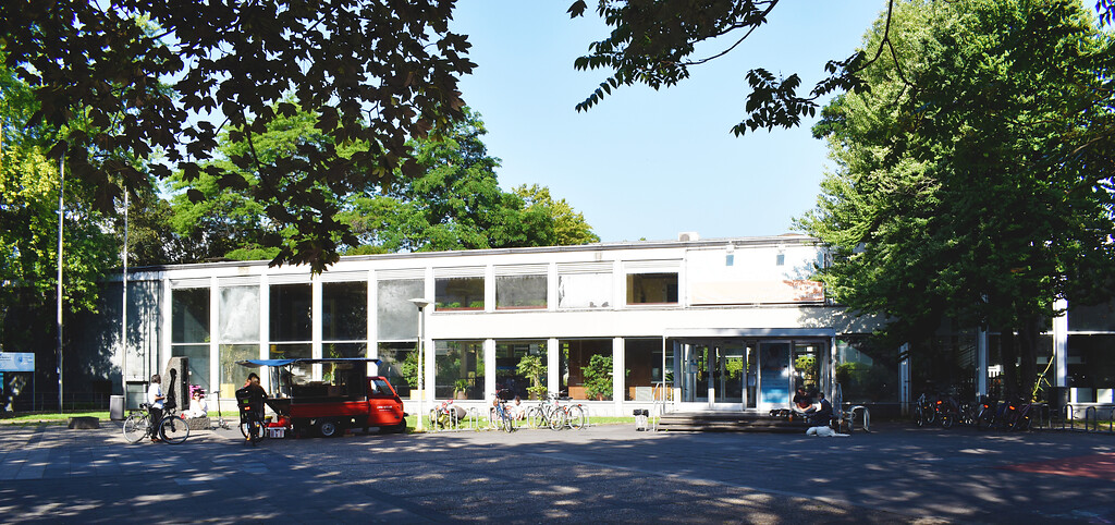 Frankenbad in Bonn, Eingangsbereich und vorliegender Frankenbadplatz, Ostseite, mit Caferoller (rot) im Vordergrund (2020).