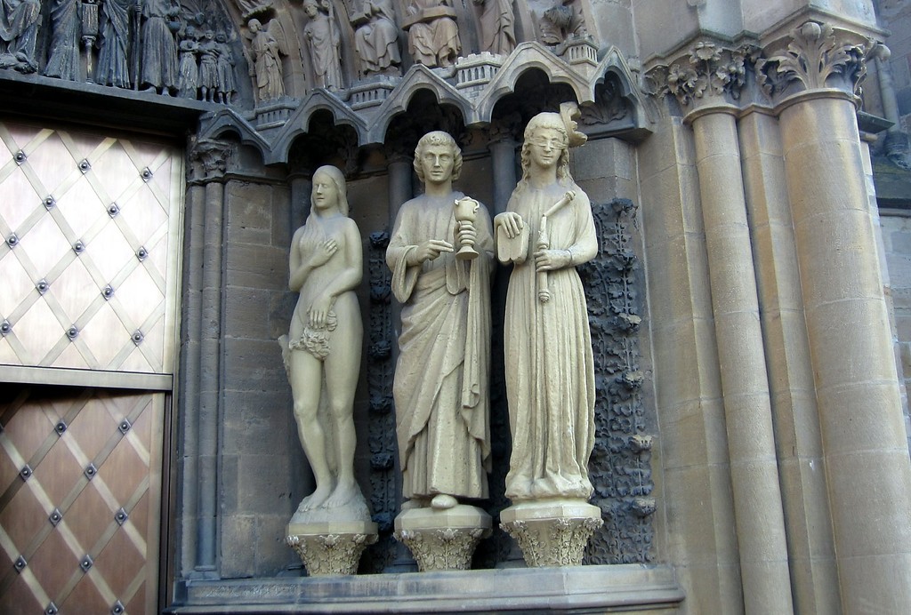 Statuen biblischer Figuren am Hauptportal der Trierer Liebfrauenkirche: von links nach rechts Eva, der Apostel Johannes und die das Judentum symbolisierende Figur der Synagoge (2012)