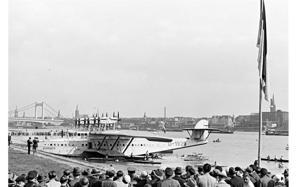 Das Flugboot Dornier Do X bei seinem Besuch in Köln 1932, im Hintergrund die damalige Mülheimer Rheinbrücke.