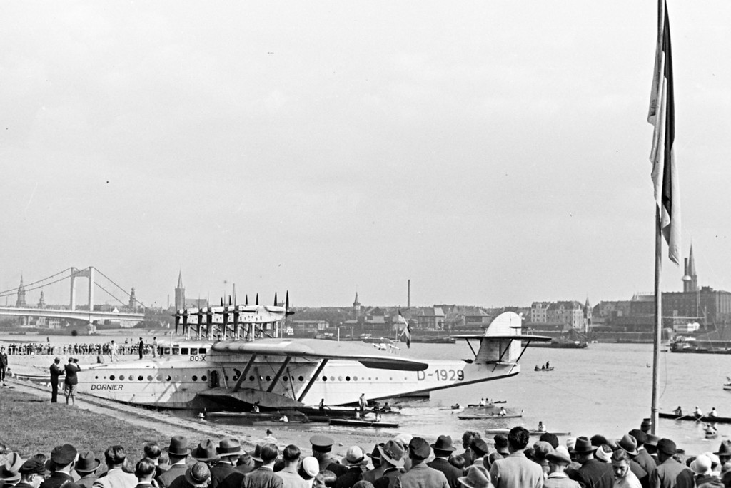Das Flugboot Dornier Do X bei seinem Besuch in Köln 1932, im Hintergrund die damalige Mülheimer Rheinbrücke.